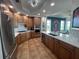 Open kitchen with wood cabinetry, white countertops, tile flooring, stainless steel appliances, and adjacent dining area at 130 Riviera Dunes Way # 304, Palmetto, FL 34221