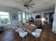 Stylish living and dining area with modern furniture, a unique dining table, and a view of the lanai at 130 Riviera Dunes Way # 304, Palmetto, FL 34221