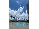 Enjoy the beautiful outdoor pool with palm trees, gazebo, and clear skies in this stunning community at 130 Riviera Dunes Way # 304, Palmetto, FL 34221
