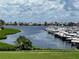Scenic waterfront view of a marina with boats docked and neighborhood homes under a cloudy sky at 130 Riviera Dunes Way # 304, Palmetto, FL 34221