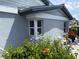 Quaint exterior of home shows blue flowers and a glimpse of outdoor seating at 1311 Siesta Bayside Dr # 1311-A, Sarasota, FL 34242