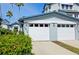 Garage doors of a two-story home featuring palm trees and lush landscaping at 1311 Siesta Bayside Dr # 1311-A, Sarasota, FL 34242