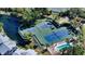 Aerial view of well-maintained pickleball and tennis courts near a pool, promoting an active lifestyle at 1311 Siesta Bayside Dr # 1311-A, Sarasota, FL 34242