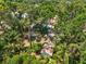 Aerial view of the property highlights the pool, shed, surrounding trees, and lush greenery at 13511 4Th Plz E, Bradenton, FL 34212