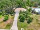 Aerial view of a charming home with a long driveway, surrounded by beautiful landscaping and mature trees at 13511 4Th Plz E, Bradenton, FL 34212