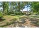 Expansive backyard featuring a large tree, green grass, and a screened-in lanai at 13511 4Th Plz E, Bradenton, FL 34212