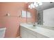 Peach bathroom featuring white vanity, mirror, and shower behind curtain at 13511 4Th Plz E, Bradenton, FL 34212