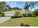 Charming yellow home boasts a well-manicured lawn and beautiful mature landscaping at 13511 4Th Plz E, Bradenton, FL 34212