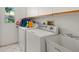 Bright laundry room features white appliances, tile flooring, and ample storage space with white cabinets at 13511 4Th Plz E, Bradenton, FL 34212