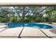 Screened-in pool with clear blue water surrounded by lush tropical greenery at 13511 4Th Plz E, Bradenton, FL 34212
