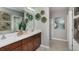 Bright, modern bathroom featuring double sinks, a vanity with wooden cabinets, and a glass-enclosed shower at 13634 Tropical Breeze Way, Hudson, FL 34669
