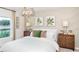 A serene bedroom with a modern light fixture, decorative wall panels, and comfortable furnishings at 13634 Tropical Breeze Way, Hudson, FL 34669