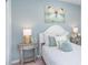 Stylish bedroom showcases a bed with decorative pillows, lamps, butterfly wall art, and attractive bedside tables at 13634 Tropical Breeze Way, Hudson, FL 34669