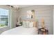 Bright bedroom featuring neutral walls, a modern light fixture, a comfortable bed, and a stylish side table at 13634 Tropical Breeze Way, Hudson, FL 34669