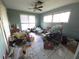 Messy bedroom with tile floor, two windows, and an overhead ceiling fan at 1450 Aqui Esta Dr, Punta Gorda, FL 33950