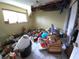Damaged bedroom featuring a window, debris, and open ceiling, awaiting complete restoration and repair at 1450 Aqui Esta Dr, Punta Gorda, FL 33950