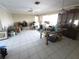 Disorganized living room featuring a tiled floor, ceiling fan, and dining set at 1450 Aqui Esta Dr, Punta Gorda, FL 33950