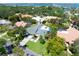 Aerial view highlighting a home with a gray roof, spacious lawn, palm trees, and a driveway in a neighborhood at 1660 Pine Harrier Cir, Sarasota, FL 34231