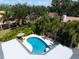 Aerial view of a private pool area with lounge chairs and an umbrella, surrounded by lush tropical foliage at 1660 Pine Harrier Cir, Sarasota, FL 34231