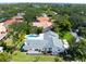 Wonderful aerial view of a home with pool, gray roof, nice landscaping, and a driveway leading to a quiet street at 1660 Pine Harrier Cir, Sarasota, FL 34231