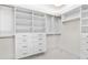 A pristine, well-organized walk-in closet boasts ample shelving and drawers for optimal storage solutions at 1660 Pine Harrier Cir, Sarasota, FL 34231