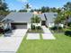 Beautiful home with a lush green lawn, modern driveway, and thoughtfully designed landscaping for curb appeal at 1660 Pine Harrier Cir, Sarasota, FL 34231