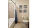 Tiled shower and toilet with decorative seashell artwork in a well-maintained bathroom at 16904 Vardon Ter # 201, Bradenton, FL 34211