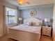 Bright bedroom featuring a large window, white furniture, and calming blue walls at 16904 Vardon Ter # 201, Bradenton, FL 34211