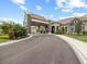 Elegant clubhouse entrance with stone accents, a covered entryway, and beautiful landscaping at 16904 Vardon Ter # 201, Bradenton, FL 34211