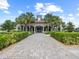 Exterior view of the clubhouse showing stone paved entry and symmetrical palm trees at 16904 Vardon Ter # 201, Bradenton, FL 34211