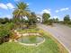 Gated community entrance features lush greenery, decorative ponds, and beautiful palm trees at 16904 Vardon Ter # 201, Bradenton, FL 34211