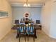 Dining area with rustic wooden table set for four, round mirror, and tile floor at 16904 Vardon Ter # 201, Bradenton, FL 34211
