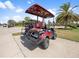 Well-equipped golf cart with comfortable seating and ample storage on a concrete path at 16904 Vardon Ter # 201, Bradenton, FL 34211