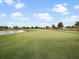 Manicured golf course fairway with lush green grass and scenic pond views on a clear day at 16904 Vardon Ter # 201, Bradenton, FL 34211