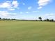 Expansive golf course view featuring manicured green lawns under a partly cloudy blue sky at 16904 Vardon Ter # 201, Bradenton, FL 34211