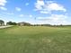 An expansive green golf course featuring ball placement and luxury home development behind it at 16904 Vardon Ter # 201, Bradenton, FL 34211