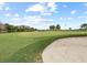 Golf course view showing sand trap and flag on the green with residential units in the distance at 16904 Vardon Ter # 201, Bradenton, FL 34211