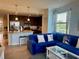 Living room with tile flooring, kitchen with granite countertops, and a comfortable blue couch at 16904 Vardon Ter # 201, Bradenton, FL 34211