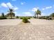 Paved parking area with parked golf carts, palm trees, and lush landscaping at 16904 Vardon Ter # 201, Bradenton, FL 34211