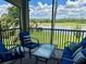 Screened patio with comfortable blue seating overlooking a lush golf course and serene lake at 16904 Vardon Ter # 201, Bradenton, FL 34211