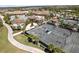 Aerial view of tennis courts, pool and clubhouse surrounded by tropical landscaping in a beautiful community at 16904 Vardon Ter # 201, Bradenton, FL 34211