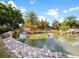 Calm pond reflecting the sky, surrounded by trees, rocks, and landscaping enhancing the natural beauty at 16904 Vardon Ter # 201, Bradenton, FL 34211