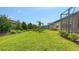Expansive green backyard with well-maintained lawn, privacy landscaping and views of other homes at 17905 Waterville Pl, Bradenton, FL 34202