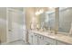 Bright bathroom featuring double sink vanity with granite counters and white cabinets at 17905 Waterville Pl, Bradenton, FL 34202