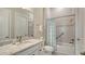 Bright bathroom featuring a white vanity with granite countertop, a tub/shower combination with blue accents at 17905 Waterville Pl, Bradenton, FL 34202
