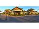Inviting exterior elevation of clubhouse featuring stone accents, porte cochere, and lush landscaping at 17905 Waterville Pl, Bradenton, FL 34202