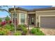 Close-up of the home entrance and front yard featuring lush plantings and stone pavers at 17905 Waterville Pl, Bradenton, FL 34202