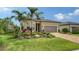Landscaped front yard of the home features a paver driveway and tropical foliage at 17905 Waterville Pl, Bradenton, FL 34202