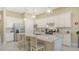 Bright kitchen featuring white cabinetry, granite countertops, stainless steel appliances, and an island with seating at 17905 Waterville Pl, Bradenton, FL 34202