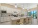 Stylish kitchen with white cabinets, granite counters, stainless appliances and an island with bar seating at 17905 Waterville Pl, Bradenton, FL 34202
